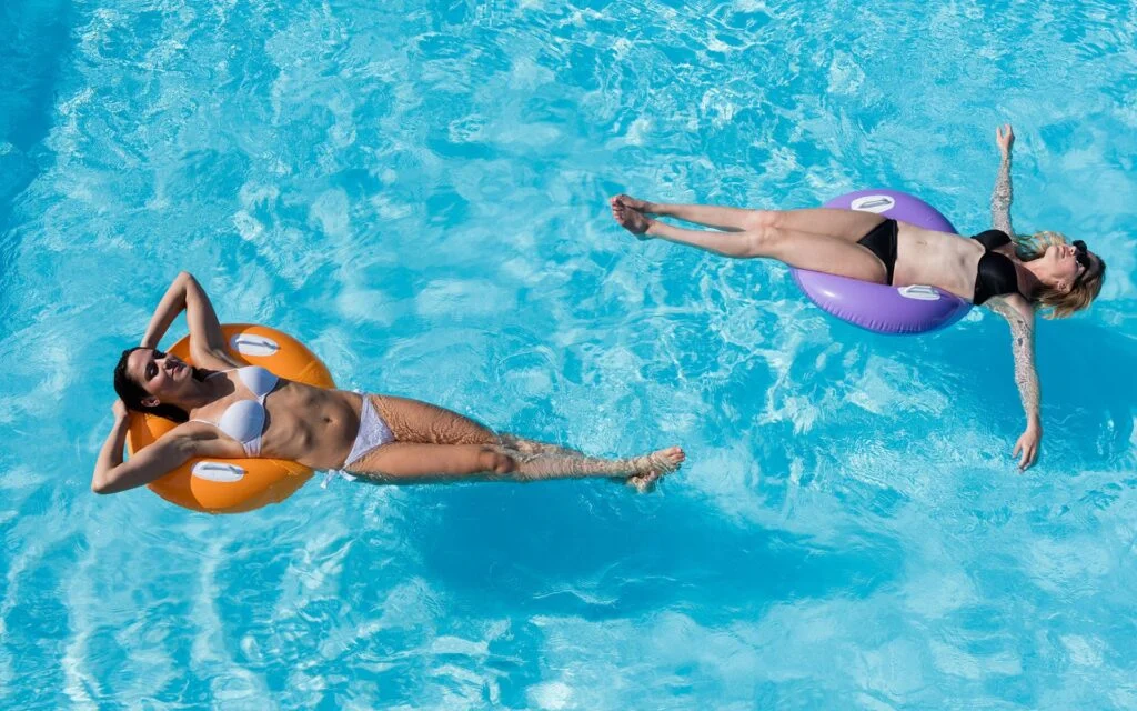 Ragazze in piscina sui materassini